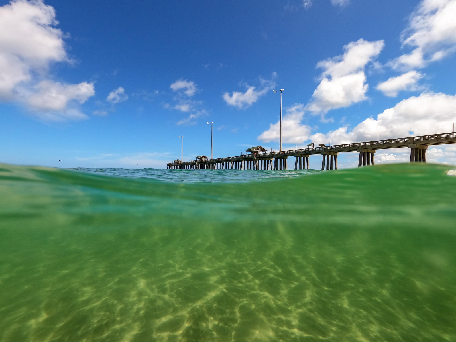View from Jennette's Pier in Nags Head, NC on a crystal clear ocean water day. The Outer Banks has been regarded as having one of the best beaches along the East Coast.