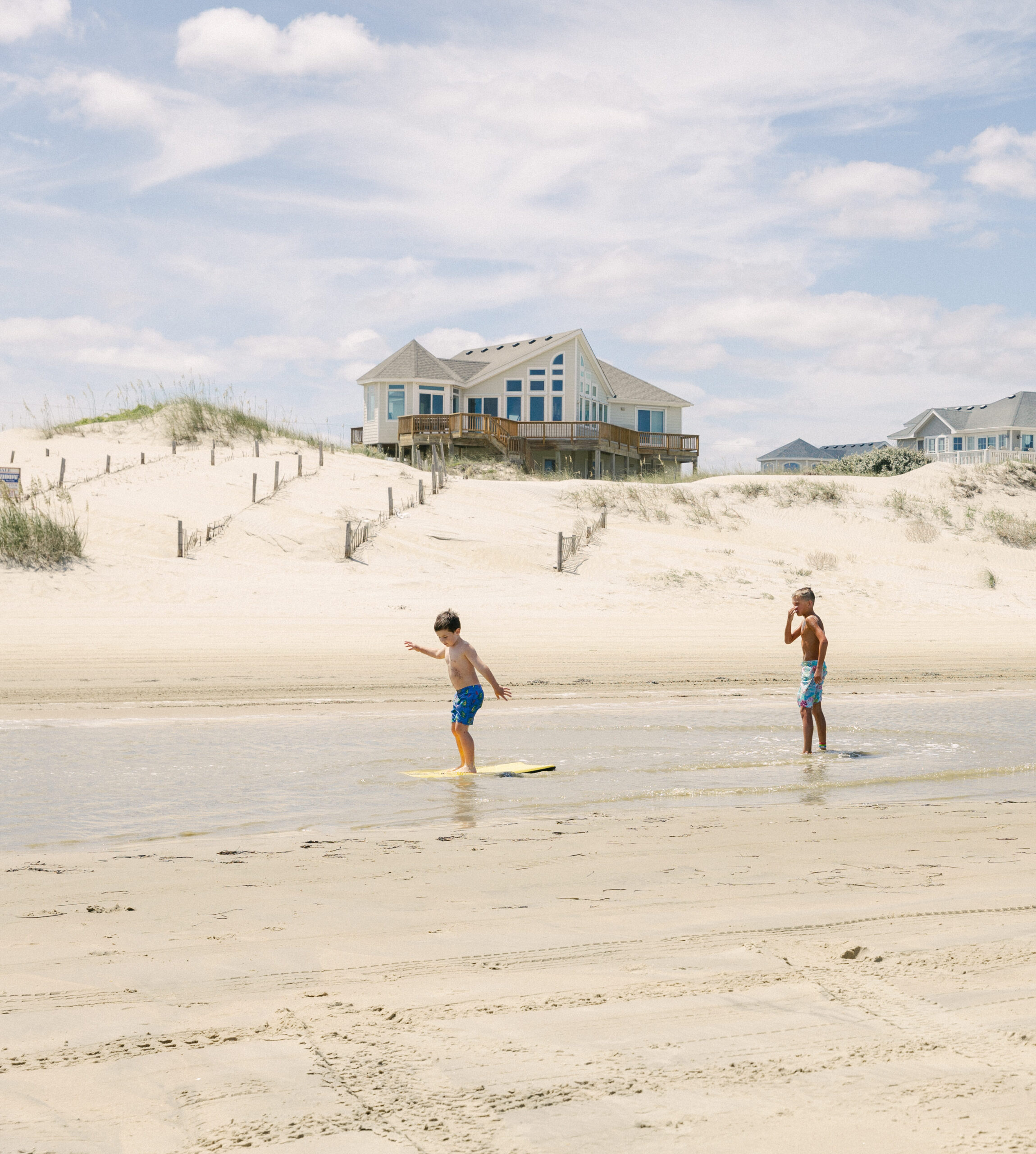 Kids playing on boogie boards in a tide pool. The Outer Banks has been regarded as having one of the best beaches along the East Coast.